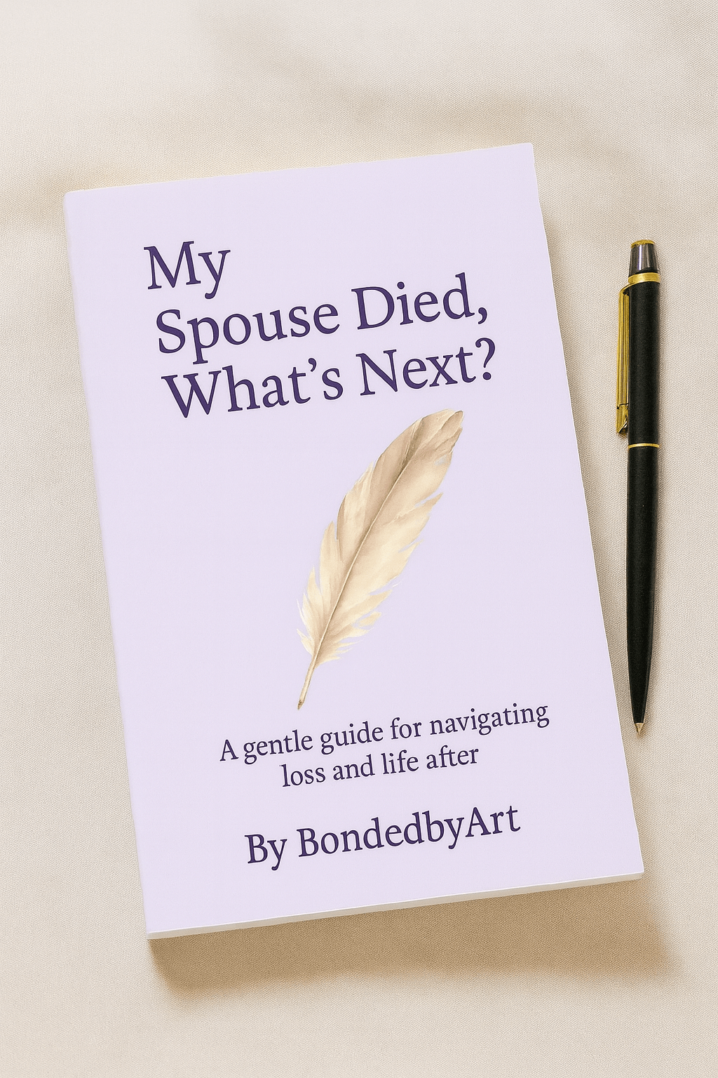 A paperback book titled 'My Spouse Died, What’s Next?' by BondedbyArt, placed on a wooden desk with a pen beside it. Styled to appear as a personal grief journal for reflection and healing.